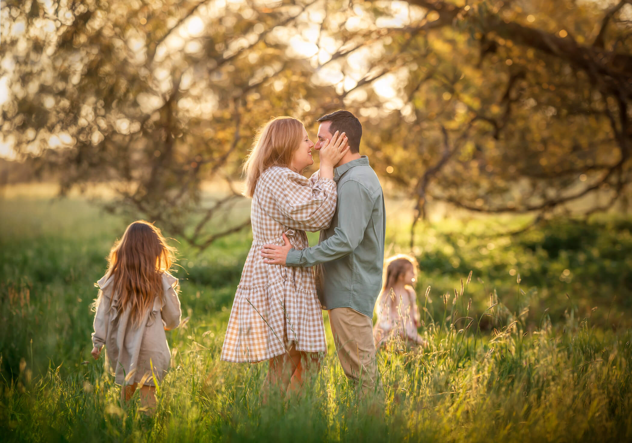 Perth couple kissing during outdoor family photo shoot at Lilac Hill in Guildford