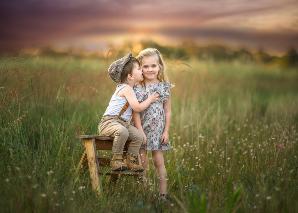Perth siblings in a grass field during sunset photo session
