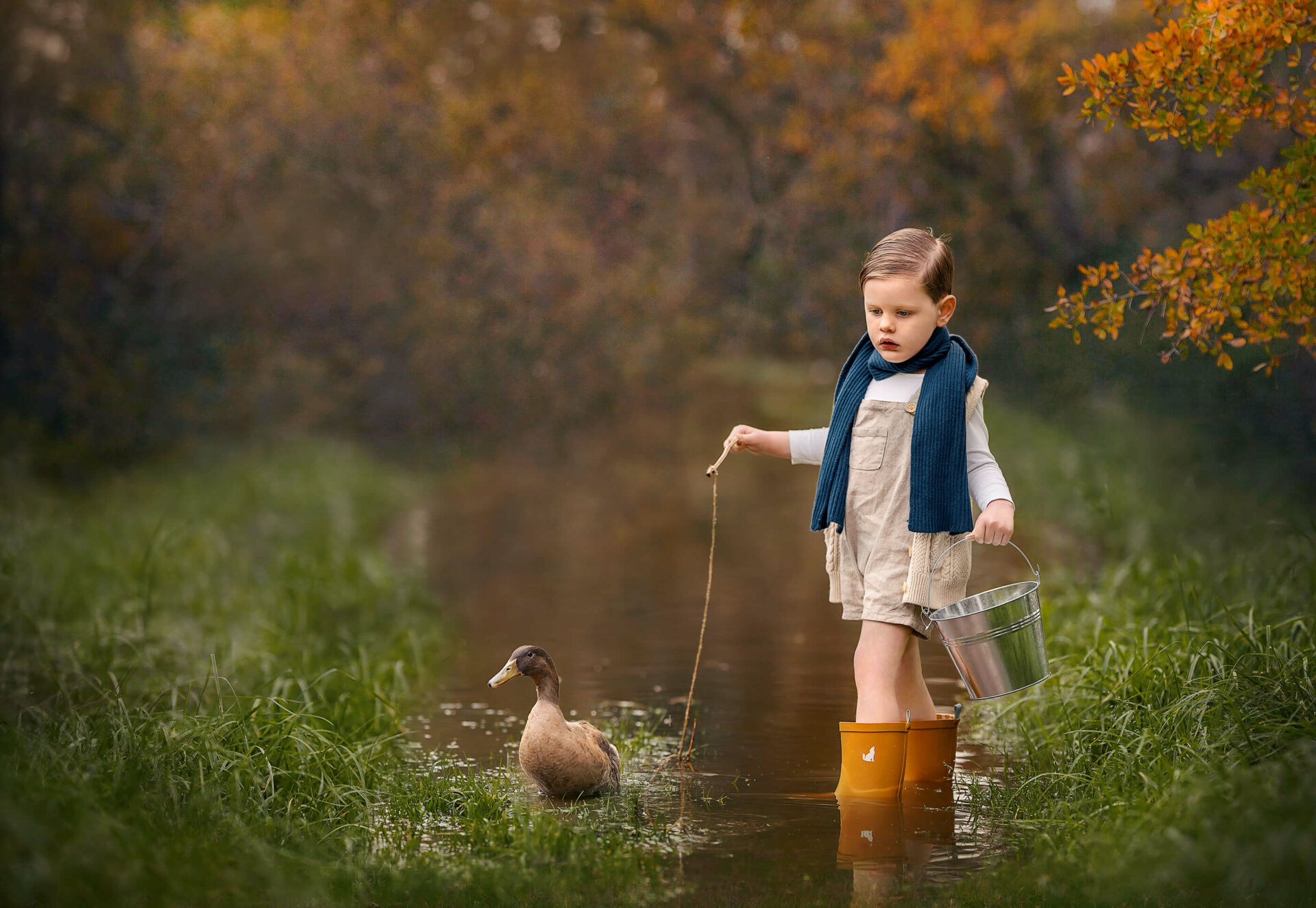 3 year old Perth boy with pet duck during outdoor water creek children's session in Perth