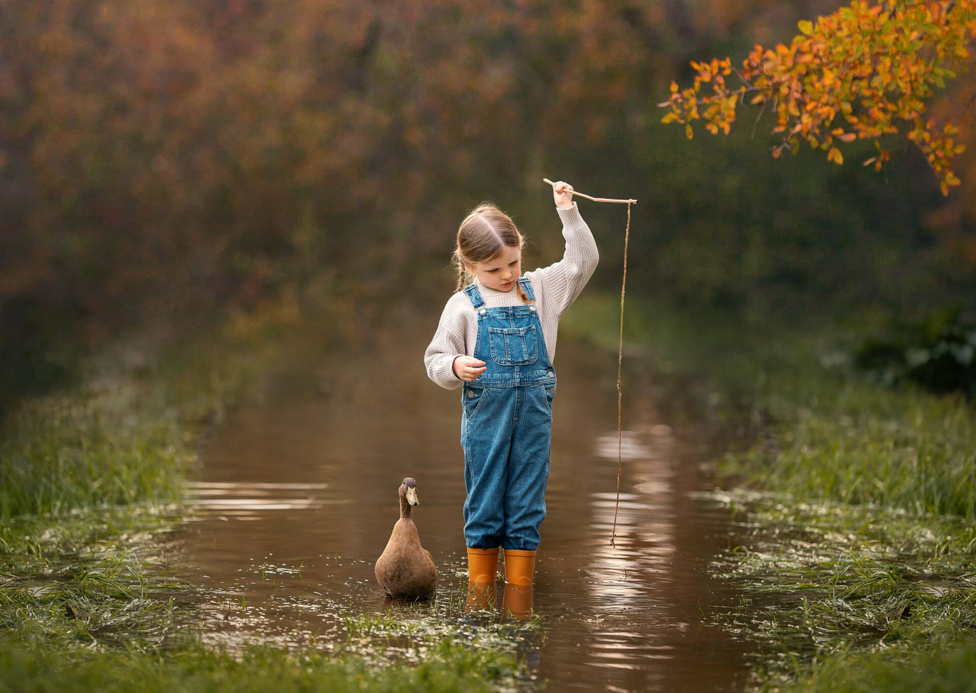 5 year old girl with pet duck during outdoor water creek children's session in Perth